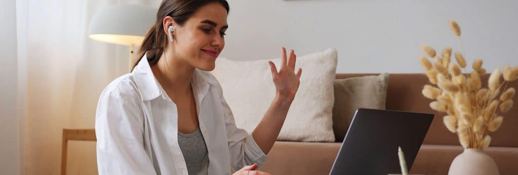 woman waves to fellow students during online group class