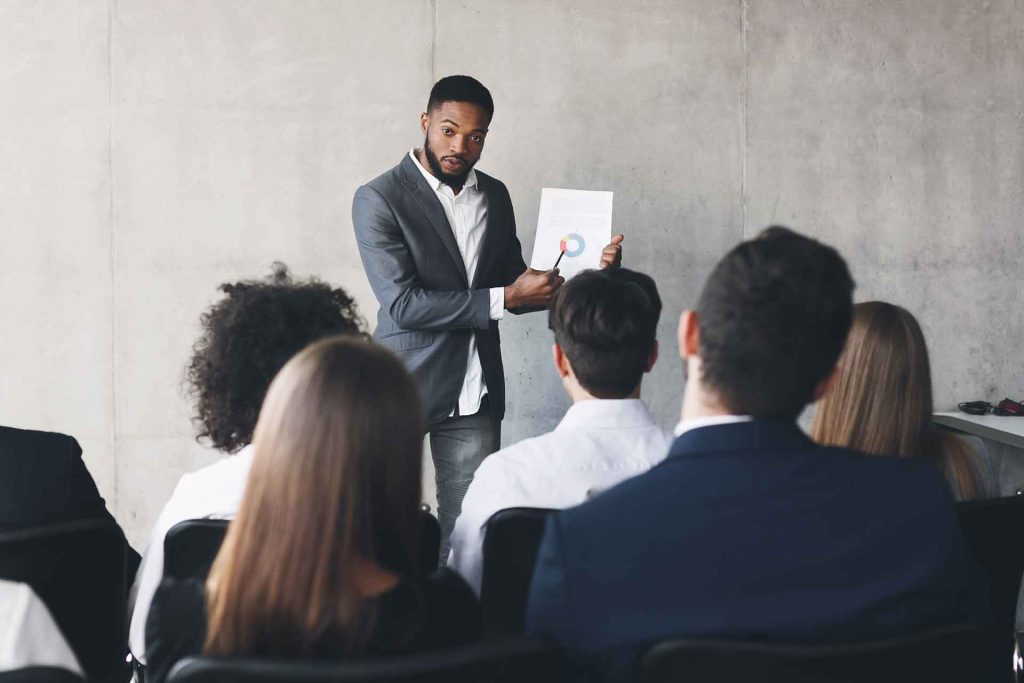 project manager gives presentation to a group of coworkers
